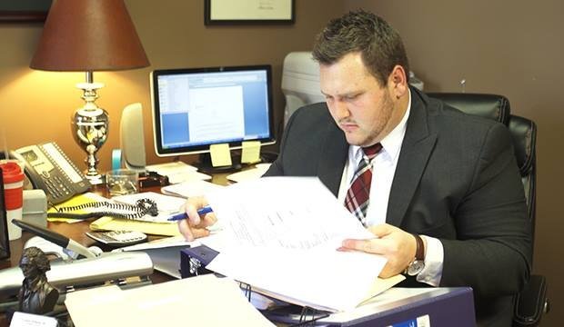 Carl Loser reviewing case documents during his paralegal work